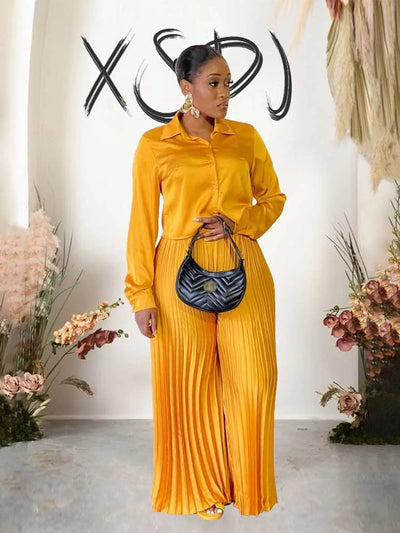 Elegant women's autumn outfit with long sleeve button top and pleated pants in yellow.